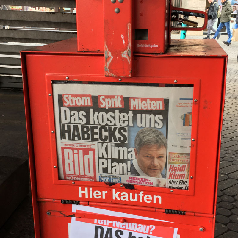 Stummer Verkäufer mit BILD Zeitung, Schlagzeile "Das kostet uns Habecks Klima Plan!" i